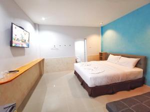 a hotel room with a bed and a tv at ลิตเติ้ล ฮิลล์ สัตหีบ รีสอร์ท ( Little Hill Sattahip Resort ) in Sattahip