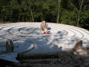 a child sitting in the middle of a labyrinth at Châteauzen in Madières