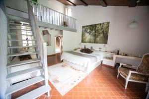 een slaapkamer met een wit bed en een trap bij Châteauzen in Madières +24 foto's