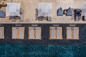 een uitzicht over de stoelen naast het zwembad bij Andronis Arcadia Hotel in Oia