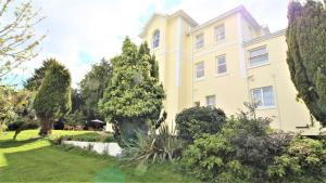a large yellow house with a garden in front of it at Chelston Dene Holiday Apartments in Torquay