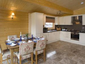a kitchen with a dining room table and chairs at Cherbridge Lodges - Riverside lodges, short lets (business or holidays) in Oxford
