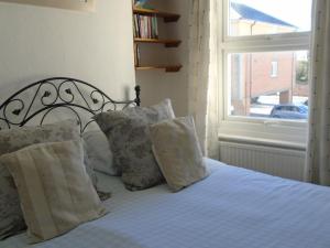 a bedroom with a bed with pillows and a window at Cherry End Bed and Breakfast in Chichester