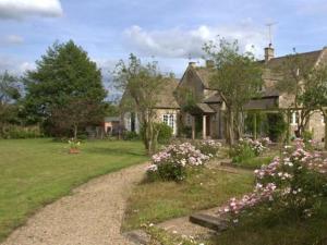 uma casa com uma estrada de cascalho em frente a um quintal em Cherry Orchard Farm em Bath