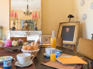- une salle à manger avec une table, du pain et du jus d'orange dans l'établissement Château de Saint-Antoine, à Bonnac-la-Côte