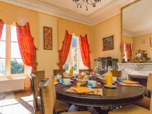 - une salle à manger avec une table, des chaises et des fenêtres dans l'établissement Château de Saint-Antoine, à Bonnac-la-Côte