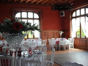 une salle à manger avec des tables et des chaises blanches dans l'établissement Château de Saint-Antoine, à Bonnac-la-Côte