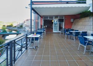 a balcony of a restaurant with tables and chairs at Hotel Apartamentos Dabarca in Pontevedra