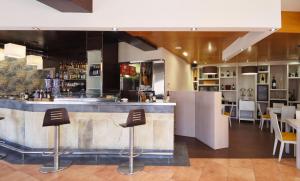 a bar in a restaurant with chairs and tables at Hotel Apartamentos Dabarca in Pontevedra