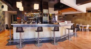 a bar with black stools in a restaurant at Hotel Apartamentos Dabarca in Pontevedra