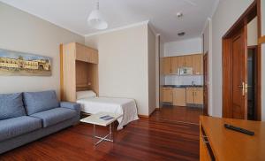 sala de estar con sofá y cocina en Hotel Apartamentos Dabarca, en Pontevedra