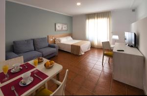 a hotel room with a bed and a living room at Hotel Apartamentos Dabarca in Pontevedra