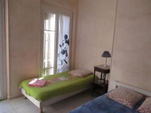 ein Schlafzimmer mit einem grünen Bett und einem Fenster in der Unterkunft Chez Brigitte Guesthouse in Nizza