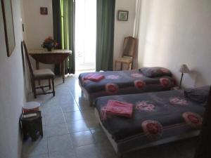 a hotel room with two beds and a table at Chez Brigitte Guesthouse in Nice