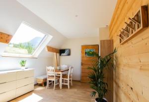 Una habitación con una mesa y sillas y una ventana. en L'étang de la Tourne, en Les Marches