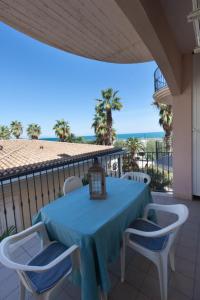 una mesa azul y sillas en un balcón con vistas al océano en Il Lauro en San Benedetto del Tronto