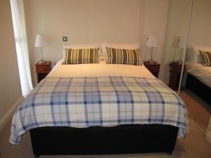 a bedroom with a bed with a checkered blanket at Churchill Two Bedroom Apartments with Free Parking and The Minster view in York