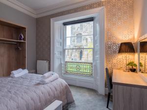 1 dormitorio con cama, escritorio y ventana en Church Lane Apartments, en Boston