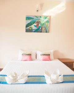 un letto bianco con due fiori bianchi sopra di Kong Krid Resort Hotel a Ban Lai Ngao
