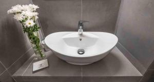 um lavatório branco numa casa de banho com flores num vaso em CASA ADA em Ortona