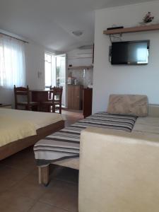 a bedroom with two beds and a tv on the wall at Studios Ivana in Umag