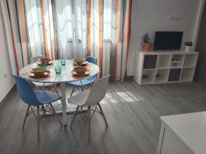 a dining room with a table and chairs and a television at Bnbook Medea Apartments in Fuengirola