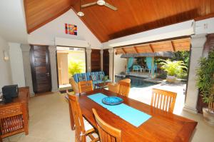 a dining room with a wooden table and chairs at Villa Oasis in Pereybere