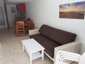 ein Wohnzimmer mit einem Sofa und einem Tisch in der Unterkunft Niza Apartamentos in Mogán