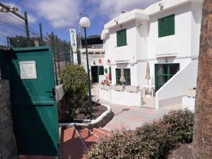 a green door in front of a white building at Niza Apartamentos in Mogán