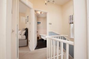 einen weißen Flur mit einem Badezimmer mit Badewanne in der Unterkunft Clarence Cottage in Whitby