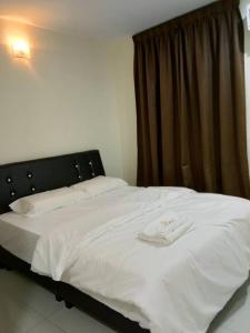 a white bed with a black head board and a window at 28 Gred Hotel in Bukit Mertajam