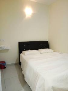 a bedroom with a large white bed with a light above it at 28 Gred Hotel in Bukit Mertajam