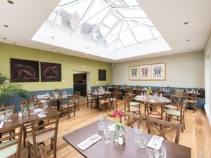 a dining room with tables and chairs and a skylight at The Cliffe at Dinham in Ludlow