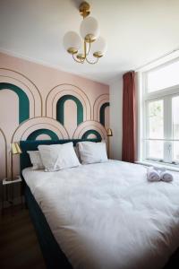 a bedroom with a large bed and a large window at MUZE Hotel Utrecht in Utrecht