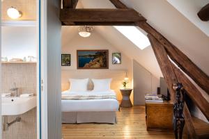 1 dormitorio con 1 cama y lavamanos en el ático en Le Clos de Villeroy, en Mennecy