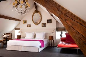 Un dormitorio con una gran cama blanca y una lámpara de araña. en Le Clos de Villeroy, en Mennecy