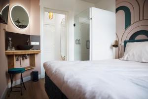 a hotel room with a bed and a dresser at MUZE Hotel Utrecht in Utrecht