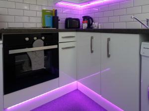 a kitchen with a pink lighting on the floor at City Hospital Apartments in Leeds