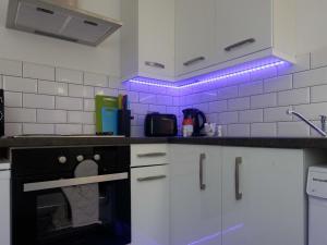 eine Küche mit lila Lichtern an der Wand in der Unterkunft City Hospital Apartments in Leeds