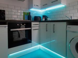 eine Küche mit blauen Lampen an den Tresen in der Unterkunft City Hospital Apartments in Leeds