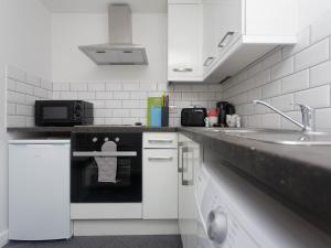 a kitchen with a black and white stove top oven at City Hospital Apartments in Leeds