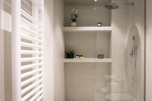 uma casa de banho branca com um chuveiro e um lavatório. em Mameli Comfort em Casale Monferrato
