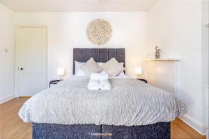 ein Schlafzimmer mit einem Bett mit zwei weißen Schuhen darauf in der Unterkunft Guest Homes - Club Chambers in Great Malvern