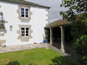 a white house with a window and a yard at Casa Oute in Sobrada