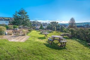 a wooden bench sitting in the middle of a grassy field at Cockhaven Arms in Bishopsteignton