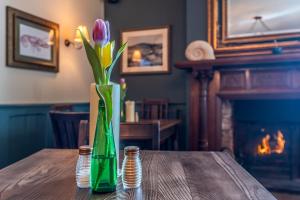 a vase filled with flowers on top of a table at Cockhaven Arms in Bishopsteignton