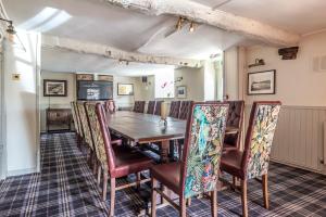 a dining room with a wooden table and chairs at Cockhaven Arms in Bishopsteignton