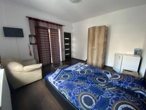 a bedroom with a bed and a chair in it at Vila Ale in Mamaia Sat/Năvodari