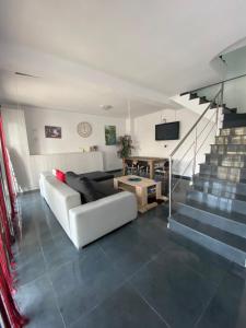 a living room with a white couch and stairs at Vila Ale in Mamaia Sat/Năvodari