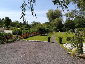 un jardín con flores y un camino de grava en Cléome, en Arques-la-Bataille